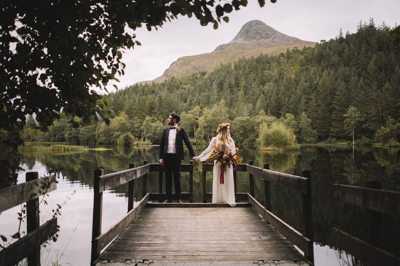 Couple holding hands in front of Glencoe lochan during their Scotland elopement