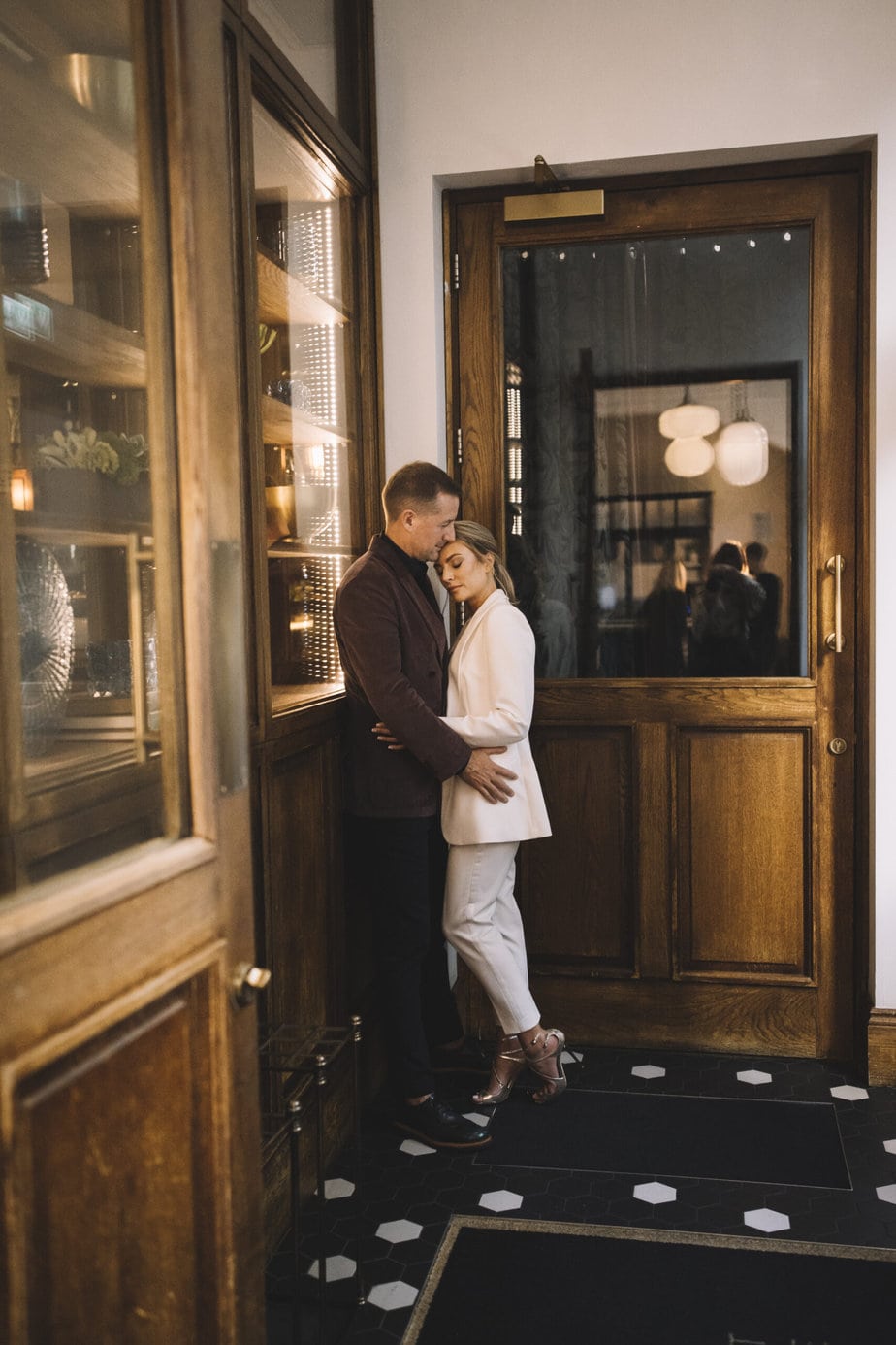 Couple cuddling in the lobby of king street town house in Manchester during their elopement. Featured on the how to elope guide.