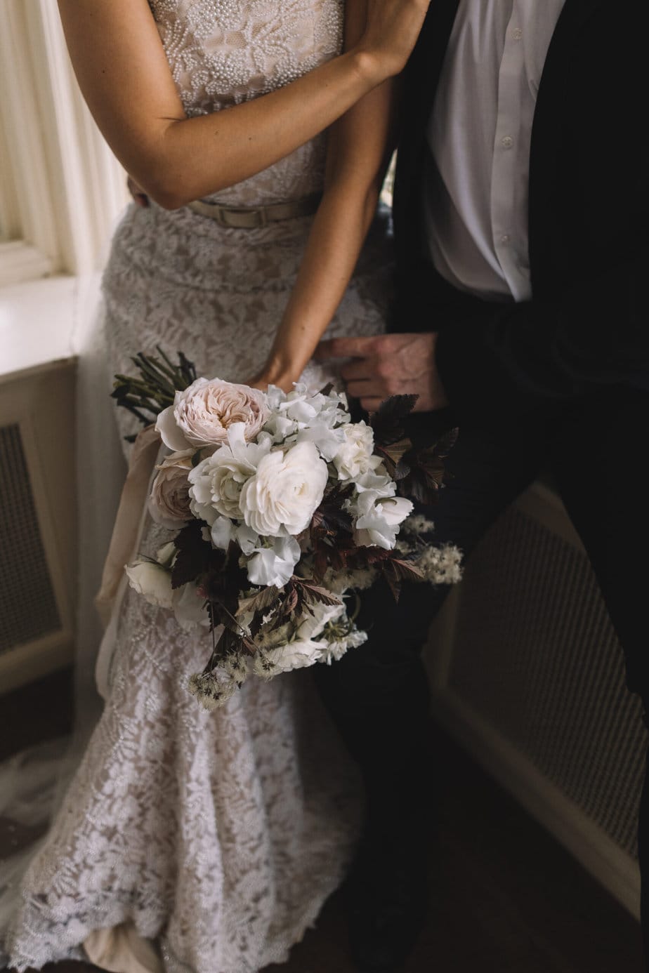 Gorgeous wedding bouquet in reds and pinks, photographed during an Edinburgh wedding at the secret herb garden.