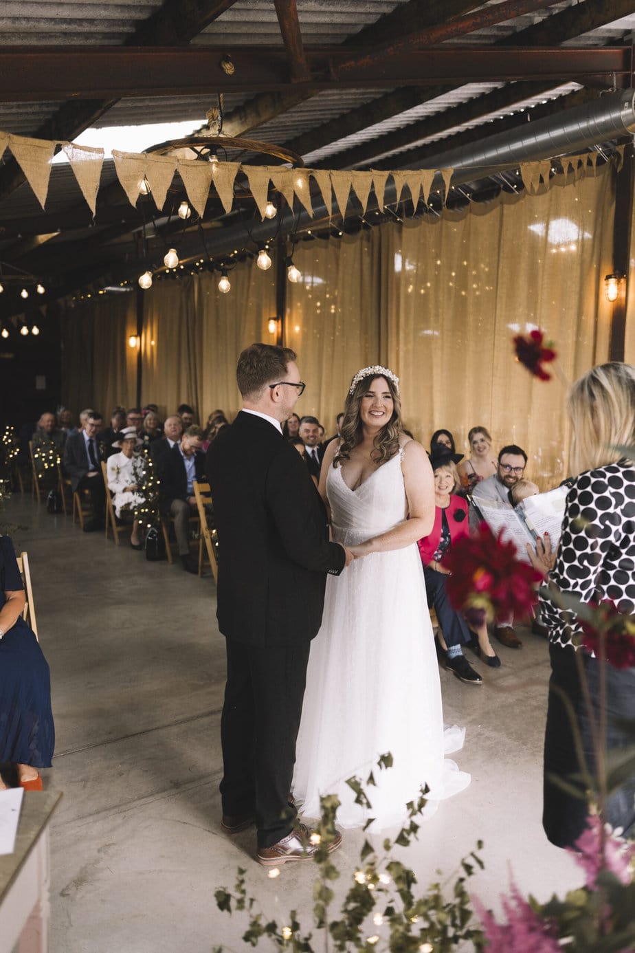 Bride and groom holding hands during their ceremony at grange farm