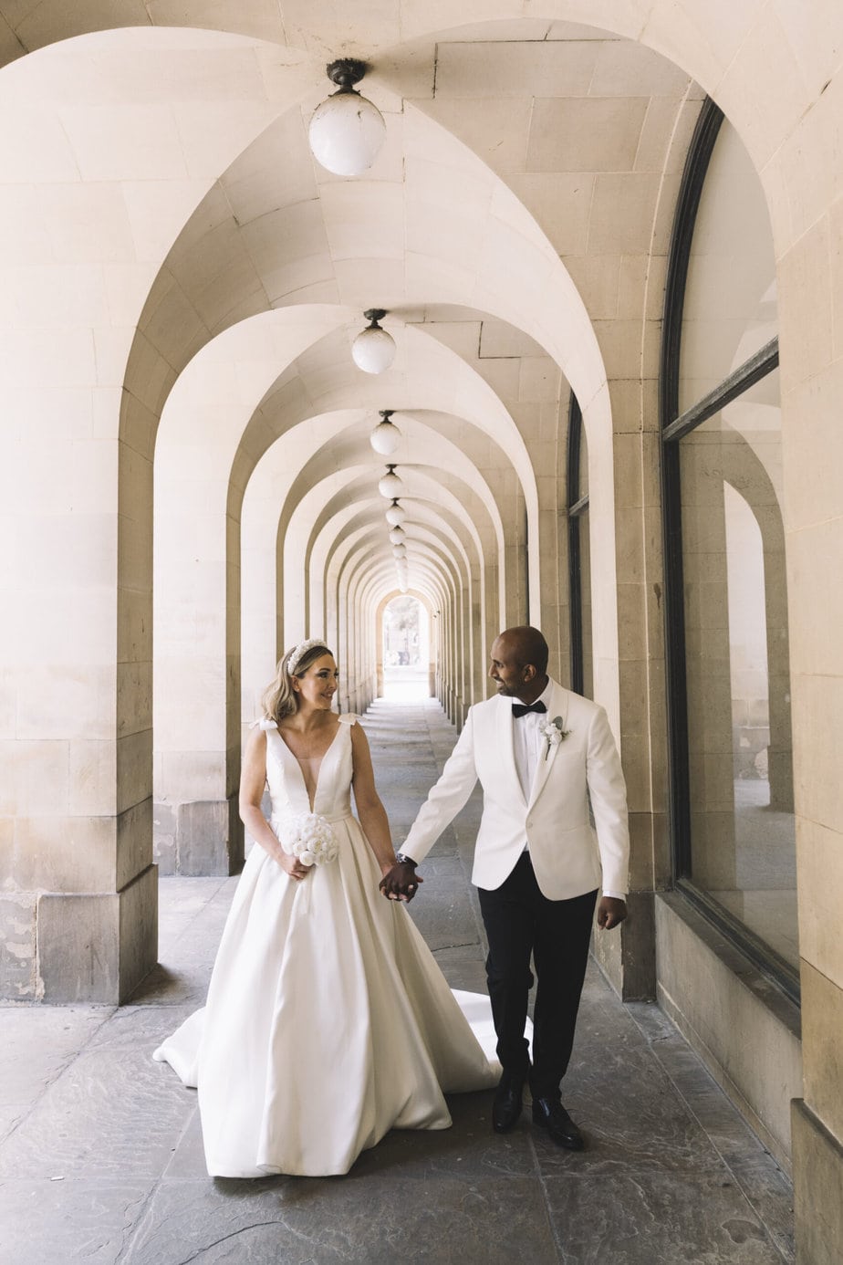 Bride and groom walking as their guests throw confetti outside Peak District church.