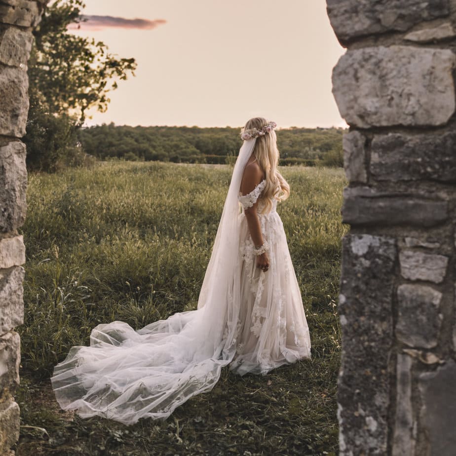 Couple sitting together on a step during wedding day, bride wears a short white dress