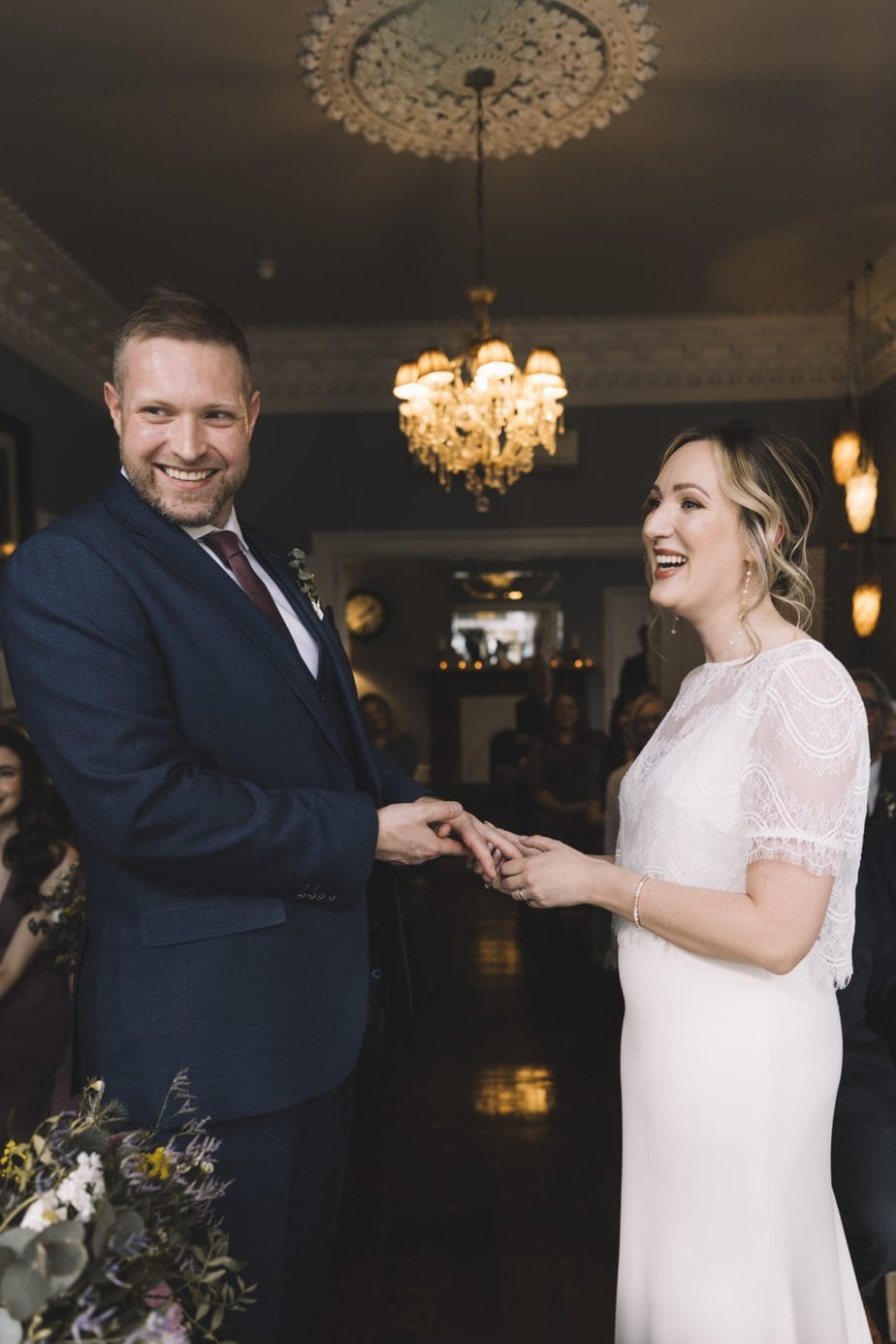 Couple holding hands and smiling during wedding ceremony at Didsbury House Hotel.
