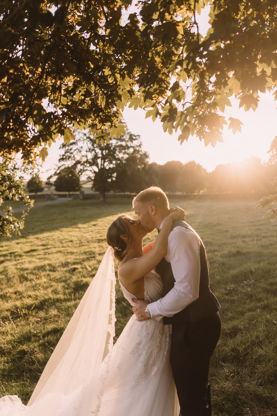 Bride and groom walking as their guests throw confetti outside Peak District church.