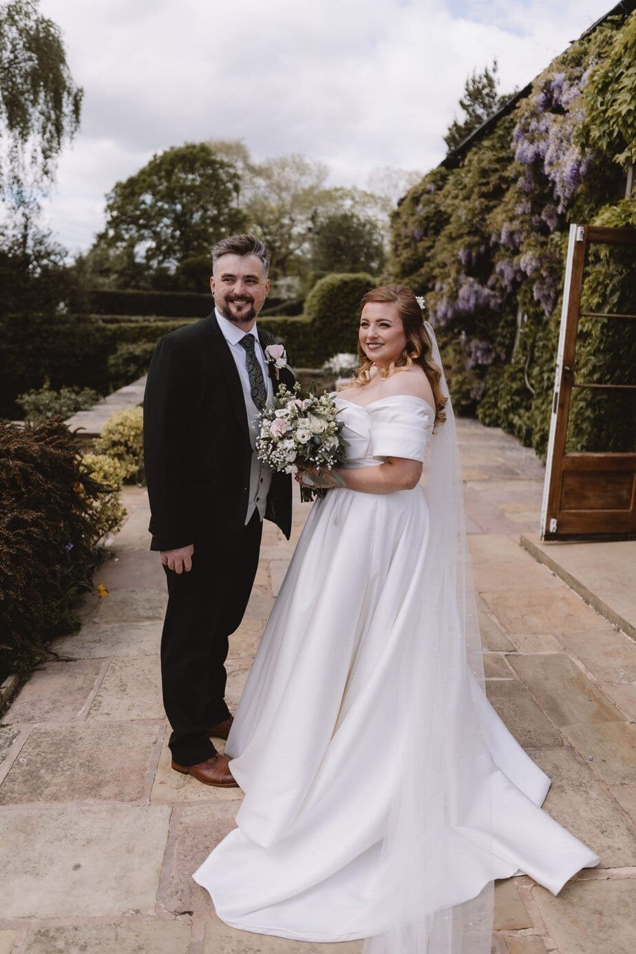 Bride and groom walking as their guests throw confetti outside Peak District church.